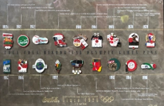 Panneau historique de pins des jeux olympiques 1928-1996 - Sponsor Coca-Cola